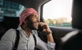 Handsome Arabic Muslim businessman looking out car window on mobile phone Royalty Free Stock Photo