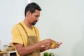 Bearded Asian man in overalls standing in kitchen He is using his hands to peel potatoes that are ready to be eaten. to prepare Royalty Free Stock Photo