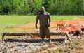 Bearded Asian Man Stares Down Obstacle Course during Annual Mud Run