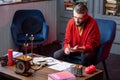 Bearded astrologist sitting in armchair reading book and doing practice