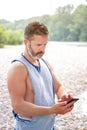 Bearded athlete outdoors looking at his phone Royalty Free Stock Photo