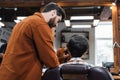 Bearded barber talking to teenage client