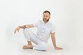 Bearded barefoot thoughtful man with tattoo sitting on the floor. Small business, yoga and pilates sports studio coach Royalty Free Stock Photo