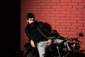 Bearded biker. bearded biker sitting on motorbikie. bearded biker in leather jacket. bearded biker in repair shop, copy