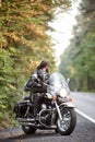 Bearded biker in black leather jacket on modern motorcycle on country roadside. Royalty Free Stock Photo