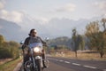 Bearded biker in black leather jacket on modern motorcycle on country roadside. Royalty Free Stock Photo