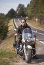 Bearded biker with long hair in black leather jacket sitting on modern motorcycle. Royalty Free Stock Photo