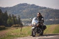 Bearded biker with long hair in black leather jacket sitting on modern motorcycle. Royalty Free Stock Photo