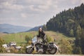 Bearded biker with long hair in black leather jacket and sunglasses sitting on modern motorcycle. Royalty Free Stock Photo