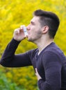 Bearded boy using asthma inhaler in park, lung disease Royalty Free Stock Photo