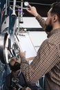 Bearded brewery worker takes readings from brewing equipment. Brewing. Brewery. Beer crafting. Royalty Free Stock Photo