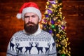 Bearded brutal hipster santa hat. xmas presents. male beard in warm winter knitted sweater. serious santa man at
