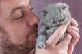 The bearded man embraces a little kitten