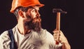 Bearded builder isolated on black background. Bearded man worker with beard, building helmet, hard hat. Hammer hammering