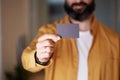 Bearded business man holding hand empty black business card on blurred background. Mockup Copy Paste Blank Advertisement Royalty Free Stock Photo