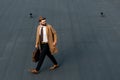 bearded businessman in coat and hat walking with hand Royalty Free Stock Photo