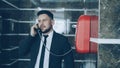 Bearded businessman dial red telephone talking with staff at reception in hotel lobby. Business, travel and people Royalty Free Stock Photo