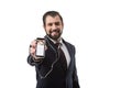 bearded businessman with earphones showing smartphone with website