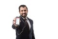 bearded businessman with earphones showing smartphone with website