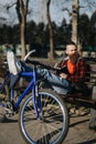Remote working businessman with a bicycle taking a break in an urban park