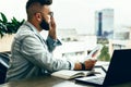 Bearded businessman hipster talking on phone while sitting at desk in office,holds document,sad looking at window. Royalty Free Stock Photo