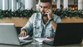 Bearded businessman hipster talking on phone while sitting at desk in office, sad looking at documents. Fall in profits. Royalty Free Stock Photo