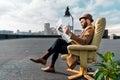 bearded businessman sitting in armchair and reading newspaper Royalty Free Stock Photo