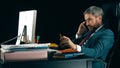 Bearded businessman talking on his cell phone. Dark background, isolated Royalty Free Stock Photo