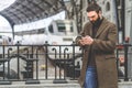 Bearded businessman texting sms message on his mobile phone.Casual professional entrepreneur using smartphone at hall of Royalty Free Stock Photo