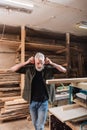 bearded carpenter adjusting protective earmuffs near