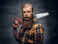 Bearded carpenter dressed in a plaid shirt holds handsaw. Royalty Free Stock Photo