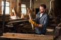 bearded carpenter in protective gloves working with wood