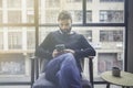 Bearded caucasian man in black pullover using mobile phone application for mobile blogging. Confident young hipster guy Royalty Free Stock Photo