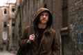 Bearded Caucasian man with brown jacket posing in front of a brick wall Royalty Free Stock Photo