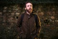 The bearded man with a brown jacket posing in front of a brick wall Royalty Free Stock Photo