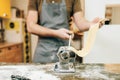 Bearded chef works with dough in pasta machine Royalty Free Stock Photo