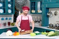 Bearded Chef in cap holds cutting wooden board in hands