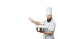 Bearded cook whisking smth in a saucepan and looking to the camera on a white background. Space for text