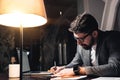 Bearded coworker working by the wood table with laptop. Creative business man make new startup at night loft office. Using modern Royalty Free Stock Photo