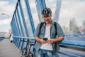 Bearded cyclist using phone while waiting for bus. Royalty Free Stock Photo