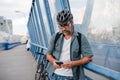 Bearded cyclist using phone while waiting for bus. Royalty Free Stock Photo