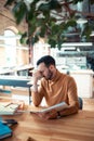 Bearded dark-haired man feeling tired after working for tool long