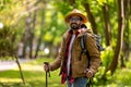 Bearded dark-haired man in a straw hat with scandinavian sticks