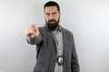 Bearded detective with police badge and serious face looking and pointing finger at the camera. Royalty Free Stock Photo