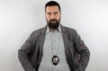 Bearded detective wearing police badge with serious face and arms on hips. Royalty Free Stock Photo