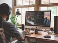 A bearded developer with headphones coding at a stylish home office desk, surrounded by natural light and plants. Royalty Free Stock Photo