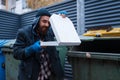 Bearded dirty beggar found pizza in trashcan