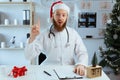 Bearded Doctor on the shift having idea pointing up with finger, looking at camera while working on Christmas eve Royalty Free Stock Photo