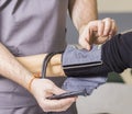 Bearded doctor wearing glasses checks the patient's blood pressure and pulse