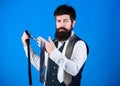 Bearded but elegant. Long bearded hipster choosing neckwear. Bearded man holding necktie. Cheerful man with unshaven Royalty Free Stock Photo